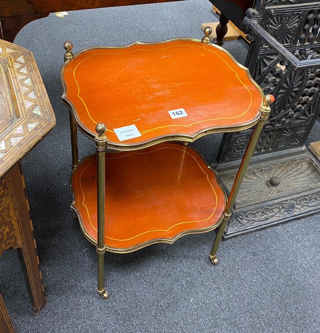 A French painted mahogany and brass two tier etagere of oval serpentine form, width 40cm, depth 32cm, height 57cm.